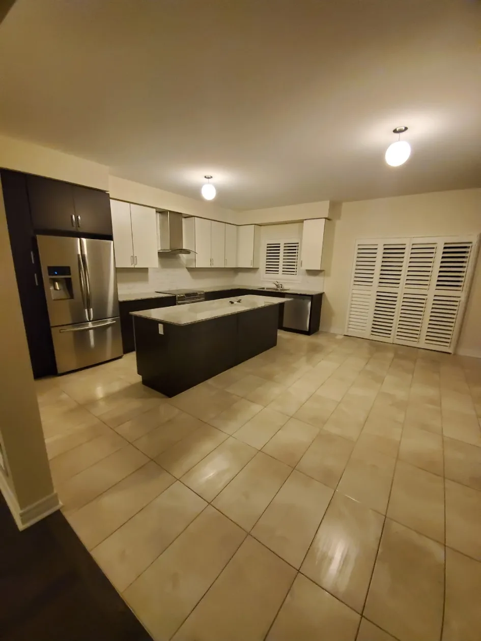 Clean kitchen with island and stainless steel appliances